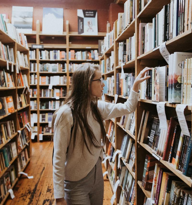 student-in-library-looking-through-books