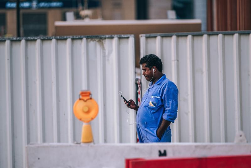 worker-blue-uniform-earphones-listening